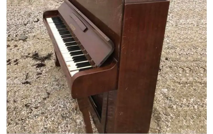 students leave piano on Beach